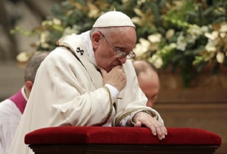 Pope Francis kneels as he leads the Christmas night mass in Saint Peter's Basilica at the Vatican December 24, 2014.