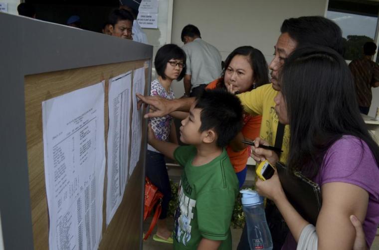 Family members of passengers on board AirAsia flight QZ 8501 look at a passenger list inside a crisis centre at Juanda Airport in Surabaya, East Java, December 28, 2014, in this photo taken by Antara Foto.