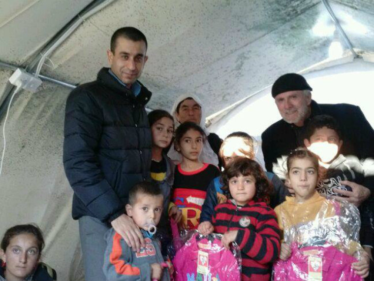 Murad Ismael and William Devlin pose for a photo with displaced children at a refugee camp in Dohuk, Iraq, in this undated photo.