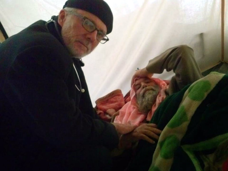 New York City pastor William Devlin ministers to a an elderly man at a refugee camp in Dohuk, Iraq, in this undated photo.