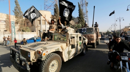 Militant Islamist fighters take part in a military parade along the streets of Syria's northern Raqqa province, June 30, 2014. The fighters held the parade to celebrate their declaration of an Islamic 'caliphate' after the group captured territory in neighbouring Iraq, a monitoring service said. The Islamic State, an al-Qaeda offshoot previously known as Islamic State in Iraq and the Levant, posted pictures online on Sunday of people waving black flags from cars and holding guns in the air, the SITE monitoring service said.