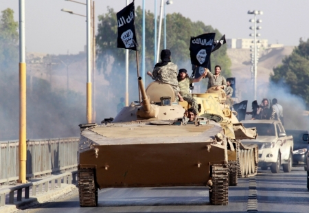 Militant Islamist fighters take part in a military parade along the streets of the northern Raqqa province, June 30, 2014. Militant Islamist fighters held a parade in Syria's northern Raqqa province to celebrate their declaration of an Islamic 'caliphate' after the group captured territory in neighbouring Iraq, a monitoring service said.