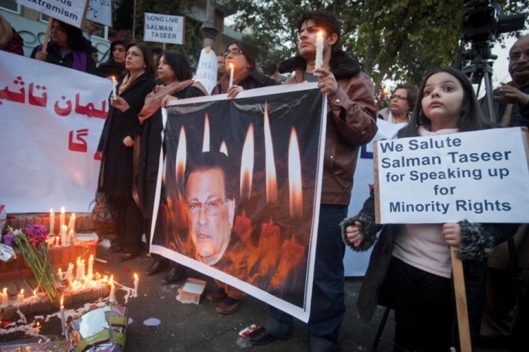 A girl holds a placard as she stands next to an image of the governor of Punjab Salman Taseer during a candlelight vigil in commemoration of Taseer, at the site where he was assassinated a day earlier, in Islamabad, Pakistan January 5, 2011. Five hundred Pakistani religious scholars have warned that anyone who expresses grief over the assassination of the senior ruling party official who opposed the country's blasphemy law could suffer the same fate. Taseer, a liberal politician close to President Asif Ali Zardari, had no day-to-day role in the central government. But his killing in broad daylight at a shopping centre in Islamabad reinforces the sense that the government is incapable of stabilising the Muslim country of 170 million.