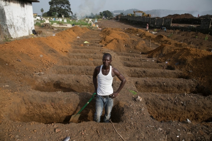 A grave digger prepares new graves at a cemetery in Freetown, Sierra Leone, December 21, 2014. About 40 suspected Ebola victims are being buried in this cemetery everyday as the country continues to fight the epidemic.