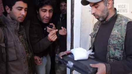 Kurdish soldiers looking over items recovered inside the home of slain ISIS leader, Emir Abu Zahra, one of which is a large bag of cocaine.