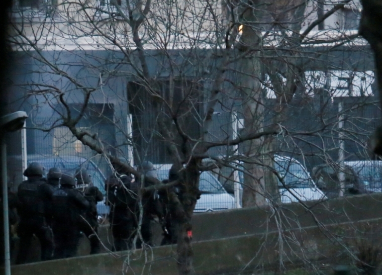 Smoke is seen at left as French police special forces launch their assault at a kosher supermarket (seen at rear) where several people were taken hostage near the Porte de Vincennes in eastern Paris, January 9, 2015, following Wednesday's deadly attack at the Paris offices of weekly satirical newspaper Charlie Hebdo by two masked gunmen who shouted Islamist slogans. Several people were taken hostage at a kosher supermarket in eastern Paris on Friday after a shootout involving a man armed with two guns, a police source said. There were unconfirmed local media reports that the man was the same as the one suspected of killing a policewoman in Montrouge, a southern suburb of Paris on Thursday.