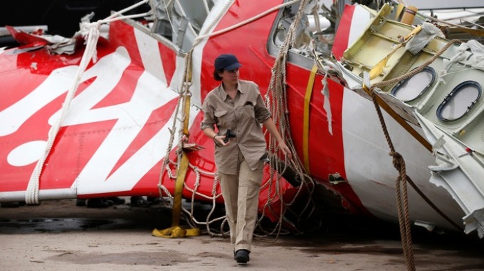 Airbus investigator walks near part of tail of AirAsia Flight 8501 in Kumai Port, near Pangkalan Bun, Indonesia on January 12, 2015.