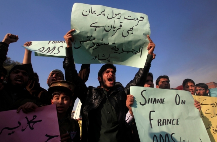 Supporters of the Al Muhammadia religious group chant slogans as they hold signs during a protest against satirical French weekly newspaper Charlie Hebdo, which featured a cartoon of the Muslim prophet Muhammad as the cover of its first edition since an attack by Islamist gunmen, in Peshawar, Pakistan, January 19, 2015. The sign reads in Urdu, 'We martyr for the prophet's sanctity.'