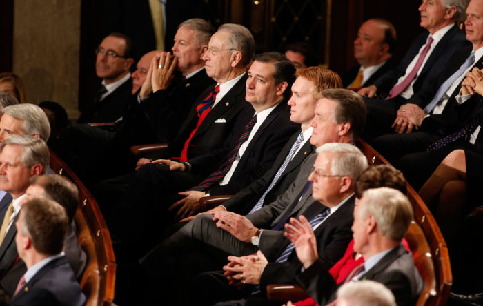 U.S. Rep. Ted Cruz (R-TX) (C) and Republican congressional colleagues listen as U.S. President Barack Obama delivers his State of the Union address to a joint session of the U.S. Congress on Capitol Hill in Washington, January 20, 2015.