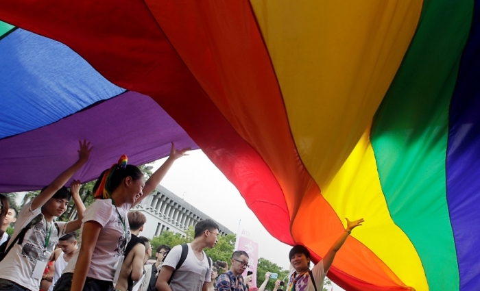 Participants hold giant rainbow flags during the Taiwan LGBT pride parade in Taipei, Taiwan, October 25, 2014. Thousands of Taiwanese gathered with people from Hong Kong, Korea and Japan on Saturday for the annual gay pride parade which is in its twelfth year, according to organizers.