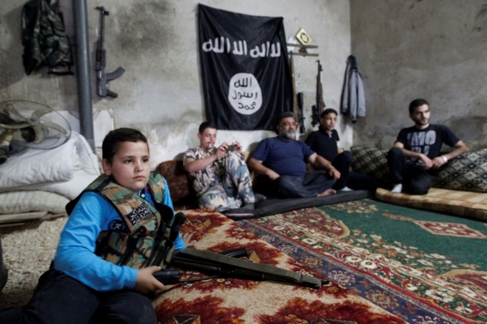 Abboud, 12, rests with fellow Free Syrian Army fighters in Aleppo's Sheikh Saeed neighbourhood, Syria, September 28, 2013. Abboud and his brother Deeb, 14, both school-going children before the civil war, joined the Free Syrian Army after the deaths of two of their brothers and an uncle in the conflict.