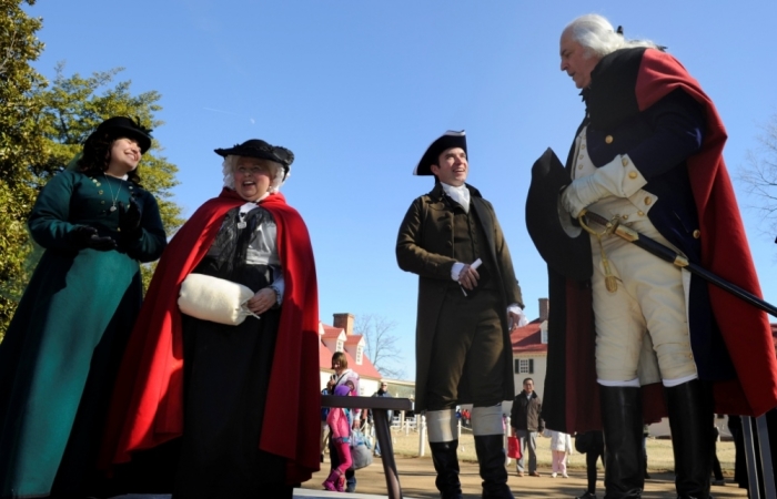 Dean Malissa (R), playing the role of U.S. President George Washington, is welcomed by David Kozisek (2nd R), who plays the role of Washington's personal secretary Tobias Lear, Natalie Fairchild (L), who plays his step-granddaughter Nelly Custis and Mary Wiseman, who plays his wife Martha Washington, during a celebration to mark President's Day at Washington's Mount Vernon estate in Alexandria, Virginia, February 18, 2013.