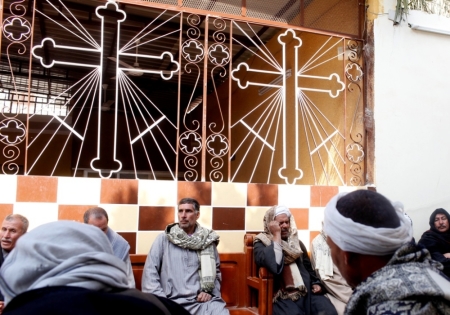 Neighbours and friends of the relatives of Egyptian Coptic men killed in Libya sit at the courtyard of a church before a mass in El-Our village, in Minya governorate, south of Cairo, February 16, 2015. Egyptian jets bombed Islamic State targets in Libya on Monday, a day after the group there released a video showing the beheading of 21 Egyptian Christians, drawing Cairo directly into the conflict across its border.