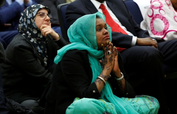 Deeqo Jibril (R), the founder of the Somali Community and Cultural Association in Boston, listens to U.S. President Barack Obama speak at the White House Summit on Countering Violent Extremism in Washington, February 18, 2015.