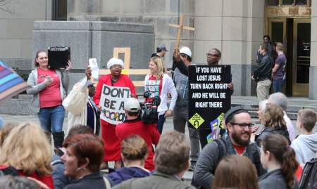 Supporters and opponents of same-sex marriage hold signs on the steps of Jefferson County Courthouse in Birmingham, Alabama February 9, 2015. Same-sex couples began marrying in Alabama on Monday despite an attempt by the conservative chief justice of the state's Supreme Court to block judges from issuing marriages licenses to gay men and women in open defiance of a January federal court ruling.