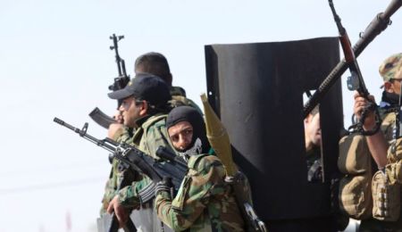 Iraqi Shi'ite fighters carry their weapons as they prepare to launch an attack on Islamic State militants on the outskirts of the city of Tikrit February 18, 2015.