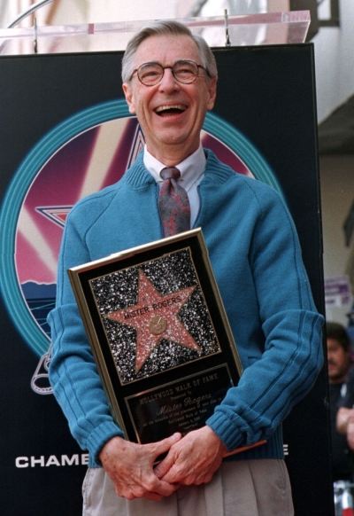 Television personality Fred Rogers, of public television's 'Mister Rogers' Neighborhood,' laughs as he poses with a plaque he received at the ceremony to unveil his star on the Hollywood Walk of Fame in Hollywood, January 8, 1998. The popular and award winning children's program is celebrating its 30th anniversary. Rogers' is the 2,101th star on the Walk of Fame.