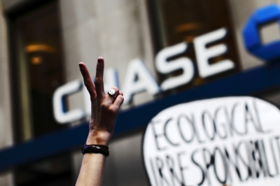 An Occupy Wall Street protestor flashes a peace sign during a march on Broadway past a Chase bank in New York's financial district September 17, 2013. The Occupy Wall Street movement celebrates their second anniversary on September 17.