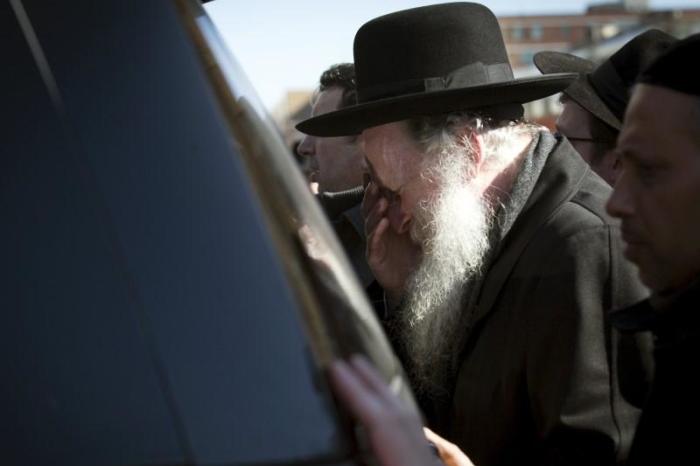 Mourners escort a car carrying the remains of one of seven children killed in a Brooklyn fire in New York March 22, 2015.