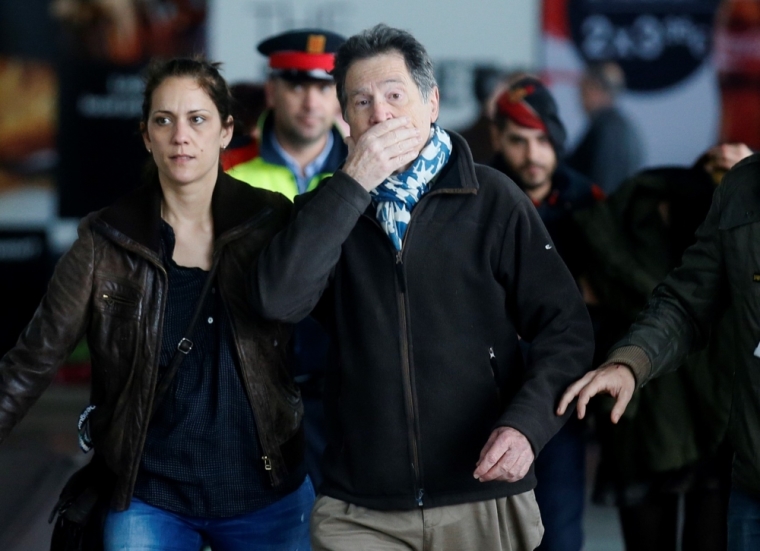 A police officer (L) escorts a man believed to be a family member of a passenger killed in Germanwings plane crash as he arrives at Barcelona's El Prat airport March 24, 2015. Lufthansa's budget carrier Germanwings confirmed its flight 4U9525 from Barcelona to Duesseldorf crashed in the French Alps. It said on its Twitter feed that 144 passengers and six crew members were on board the Airbus A320 aircraft.