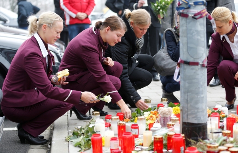 Germanwings employees cry as they place flowers and lit candles outside the company headquarters in Cologne Bonn airport March 25, 2015. An Airbus operated by Lufthansa's Germanwings budget airline crashed in a remote snowy area of the French Alps on Tuesday, killing all 150 on board including 16 schoolchildren.