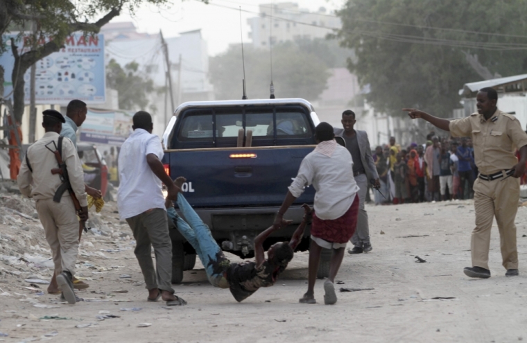 Residents evacuate an injured boy after Islamist group al Shabaab attacked Maka Al-Mukarama hotel in Mogadishu, March 27, 2015. Islamist militants blasted their way into a popular hotel in the Somali capital Mogadishu on Friday, killing at least seven people and trapping government officials inside, police and witnesses said.