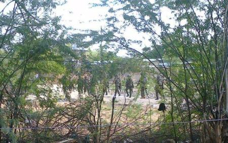 Kenya Defence Forces soldiers move behind a thicket in Garissa town in this photograph taken from a mobile phone April 2, 2015.