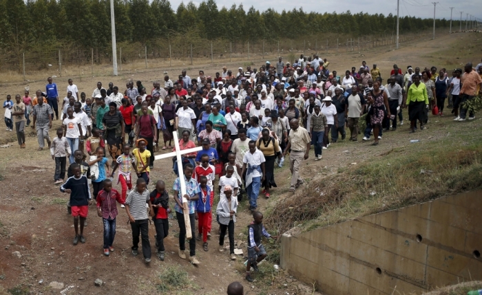 A Christian man carries a cross during Good Friday procession outside Nairobi, Kenya, April 3, 2015.