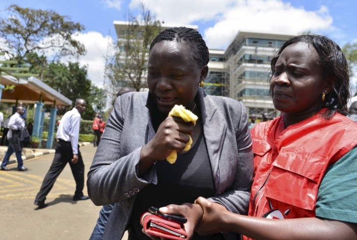 A relative is assisted by Red Cross staff as bodies of the students killed in Thursday's attack by gunmen, arrive at the Chiromo Mortuary in Nairobi, April 3, 2015. The death toll in an assault by Somali militants on a Kenyan university is likely to climb above 147, a government source and media said on Friday, as anger grew among local residents over what they say was a government failure to prevent bloodshed. Strapped with explosives, masked al Shabaab gunmen stormed the Garissa University College campus in a pre-dawn rampage on Thursday.