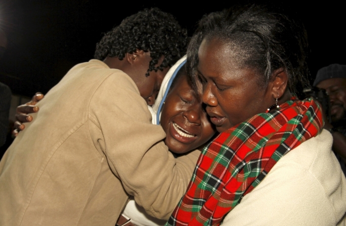 People react after meeting their relative (C) who was rescued from the Garissa University attack at Nyayo stadium in Kenya's capital Nairobi, April 4, 2015, following Thursday's siege by gunmen in their campus in Garissa. Kenya's President Uhuru Kenyatta said on Saturday that those behind an attack in which al-Shabaab Islamist militants killed 148 people at a university were 'deeply embedded' in Kenya, and called on Kenyan Muslims to help prevent radicalization. The stadium is now a crisis center manned by the Red Cross, for families to find out whether their relatives are alive or dead.