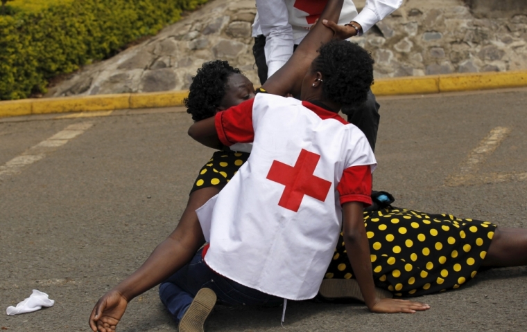 A relative falls while she is assisted by Kenya Red Cross staff where bodies of the students killed in Thursday's attack by gunmen, are preserved at the Chiromo Mortuary in the capital Nairobi, April 4, 2015. Somali militants vowed on Saturday to wage a long war against Kenya and run its cities 'red with blood' after the group's fighters killed nearly 150 people during an assault on a Kenyan university.