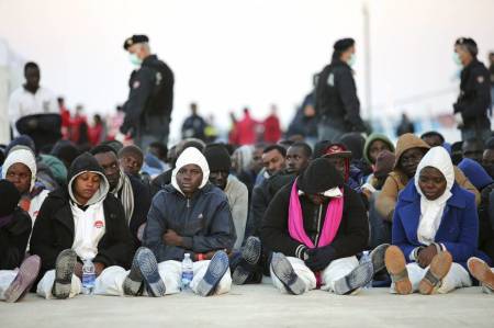 Migrants rest after they disembarked in the Sicilian harbour of Augusta, April 16, 2015. Italian police arrested 15 African men suspected of throwing about a dozen Christians from a migrant boat in the Mediterranean on Thursday, as the crisis off southern Italy intensified.