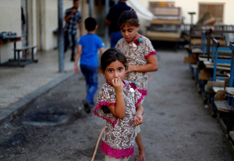 A displaced Iraqi girl, who fled from the violence in Mosul, stands at a school in Baghdad, September 1, 2014. Picture taken September 1, 2014.