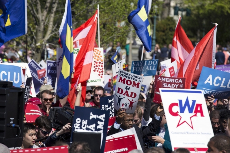 Demonstrators who are for and opposed to gay marriage rally at the Supreme Court in Washington, April 28, 2015. The Supreme Court appeared sharply divided on Tuesday along ideological lines on whether the Constitution guarantees a right to same-sex marriage, but Justice Anthony Kennedy, a pivotal vote, seemed open to legalizing gay marriage nationwide.