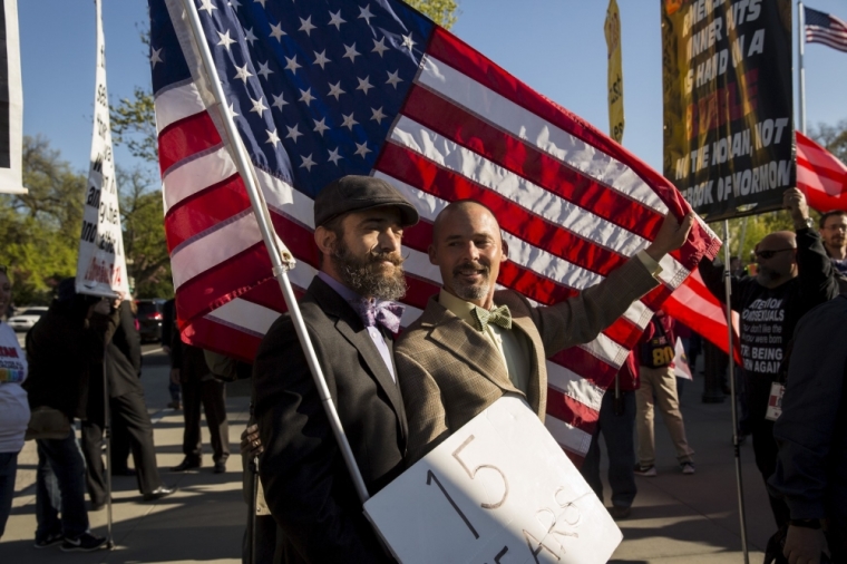 Gay marriage supporters Joe (L) and Frank Capley-Alafano of Oakland, California, stand in front of the Supreme Court before a hearing about gay marriage in Washington, April 28, 2015. The nine justices will be hearing arguments concerning gay marriage restrictions imposed in Kentucky, Michigan, Ohio and Tennessee, four of the 13 states that still outlaw such marriages.