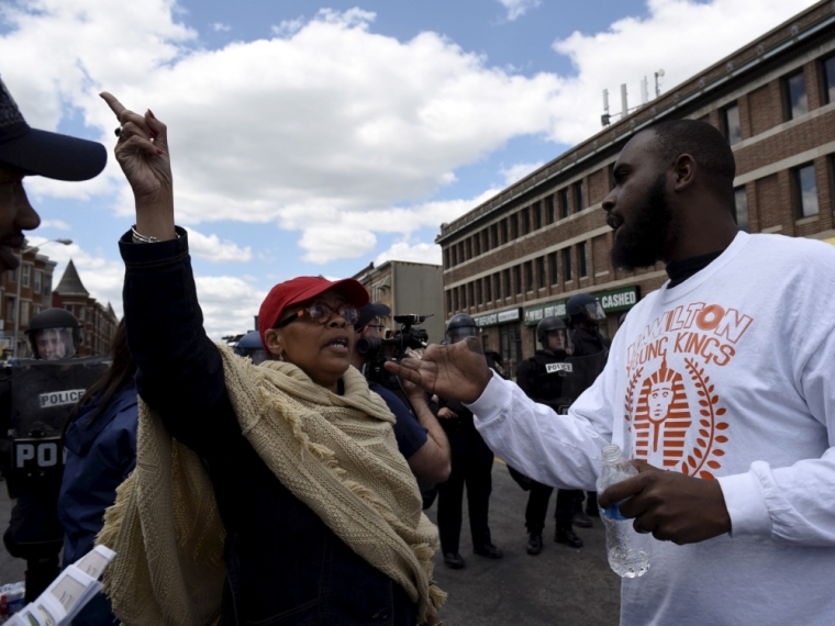 Two protesters debate near the CVS Pharmacy building on Pennsylvania Avenue in Baltimore, Maryland, April 28, 2015. Hundreds of rioters looted businesses and set buildings on fire, including the pharmacy, in Baltimore on Monday in widespread violence that injured at least 15 police officers following the funeral of Freddie Gray, a 25-year-old black man who died after he was injured in police custody.