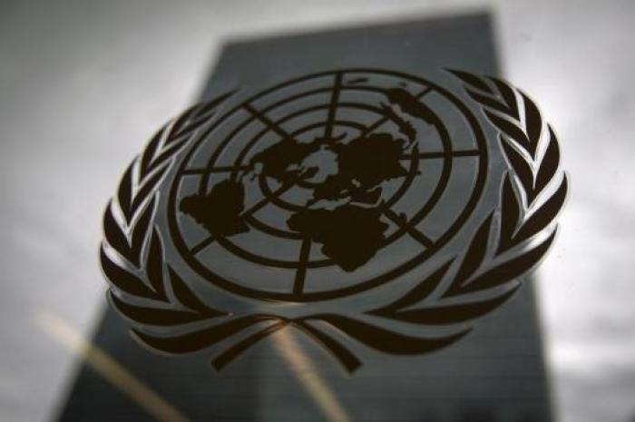 The United Nations headquarters building is pictured though a window with the UN logo in the foreground in Manhattan.