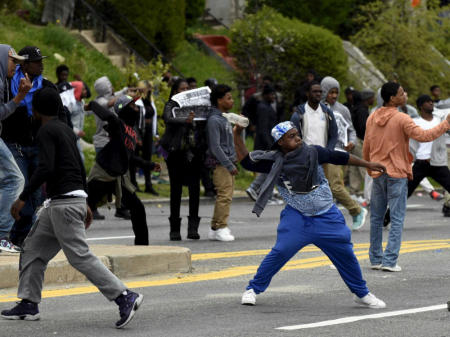 Young people throw rocks at police officers during a clash at Mondawmin Mall on April 27, 2015, in Baltimore, Md.