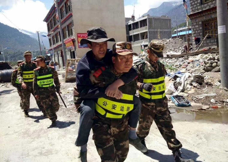 A rescuer carries a man on his back as authorities carry out rescue operations after a fresh 7.3-magnitude earthquake hit Nepal, in Gyirong county, Tibet Autonomous Region, China, May 12, 2015.