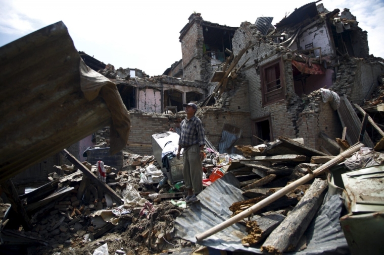 A man stands on the debris of collapsed houses after a fresh 7.3-magnitude earthquake struck Nepal, in Sankhu May 12, 2015.