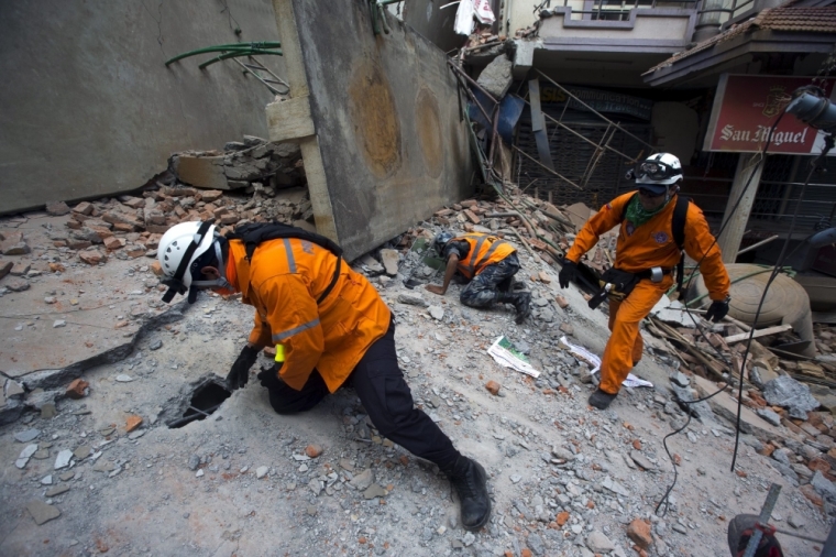 Nepalese military personnel and International rescue check on a collapsed building after an earthquake in the center of Kathmandu, Nepal, May 12, 2015.