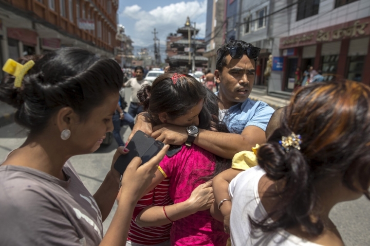 Local residents comfort each others during an earthquake in central Kathmandu, Nepal, May 12, 2015. At least three people were killed and more than 300 injured in Nepal after a magnitude 7.3 earthquake shook the Himalayan nation on Tuesday, police said. The latest casualties came just weeks after a devastating quake, with a magnitude of 7.8, killed more than 8,000 people in Nepal and damaged hundreds of thousands of buildings.