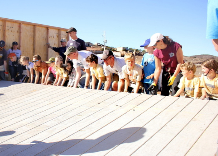 Volunteers raising wall for a house as part of a 'Homes for Hope' project.