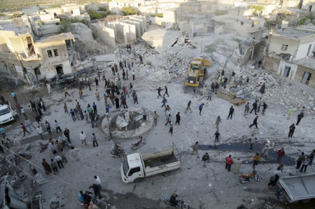 Residents gather at a site hit by an airstrike by forces loyal to Syria's President Bashar Al Assad in Billion village in the Jabal Al Zawiya region in May 2015.