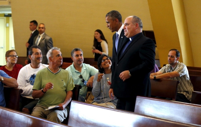 Worshippers look up as U.S. President Barack Obama (C) visits the Shrine of Our Lady of Charity in Miami, Florida, May 28, 2015. Leading Obama is Father Juan Rumin Dominguez.