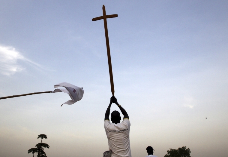 A southern Sudanese man wears a T-shirt reading, 'Vote For Your Freedom,' as he holds up a cross during a Christmas Eve procession in Juba, December 24, 2010. The referendum on southern independence was promised in a 2005 peace deal that ended decades of north-south civil war and analysts have warned disagreements over the vote could reignite conflict.