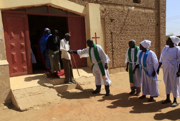 Pastors help South Sudanese worshipers after attending Sunday prayers in Baraka Parish church at Hajj Yusuf, on the outskirts of Khartoum, February 10, 2013. Sudan's President Omar Hassan al-Bashir has said he wants to adopt a '100 percent' Islamic constitution now that the South has split off. The government says the new constitution will guarantee religious freedom, but many Christians are wary. They say authorities started a crackdown in December and it has been getting worse.