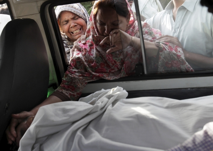 The sister of Aftab Bahadur touches her brother's face after his body was placed in a van to be taken for burial following his execution at Kot Lakhpat jail in Lahore, Pakistan, June 10, 2015. Pakistan on Wednesday executed Bahadur, who was 15 when he was sentenced to death for murder and whose lawyers say was tortured into confessing, in a case that has prompted concern among rights groups and the United Nations.