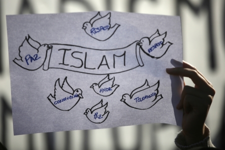 A girl holds up a sign during a rally by members of the Muslim community of Madrid outside Madrid's Atocha train station, January 11, 2015, in solidarity with the victims of a shooting by gunmen at the Paris offices of the satirical weekly newspaper Charlie Hebdo, and against Islamophobia. The words on the birds read, 'Peace, Respect, Love, Tolerance and Coexistence'.