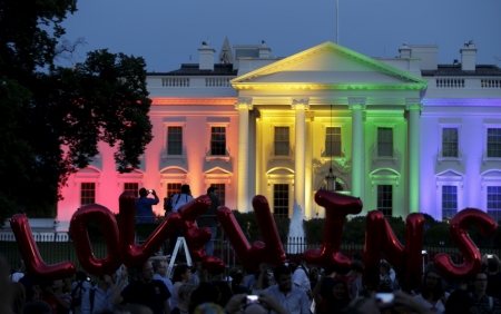 People stand in front of the rainbow-colored illuminated White House with balloons that say 'Love Wins'after today's historic Supreme Court ruling legalizing gay marriage in Washington June 26, 2015.